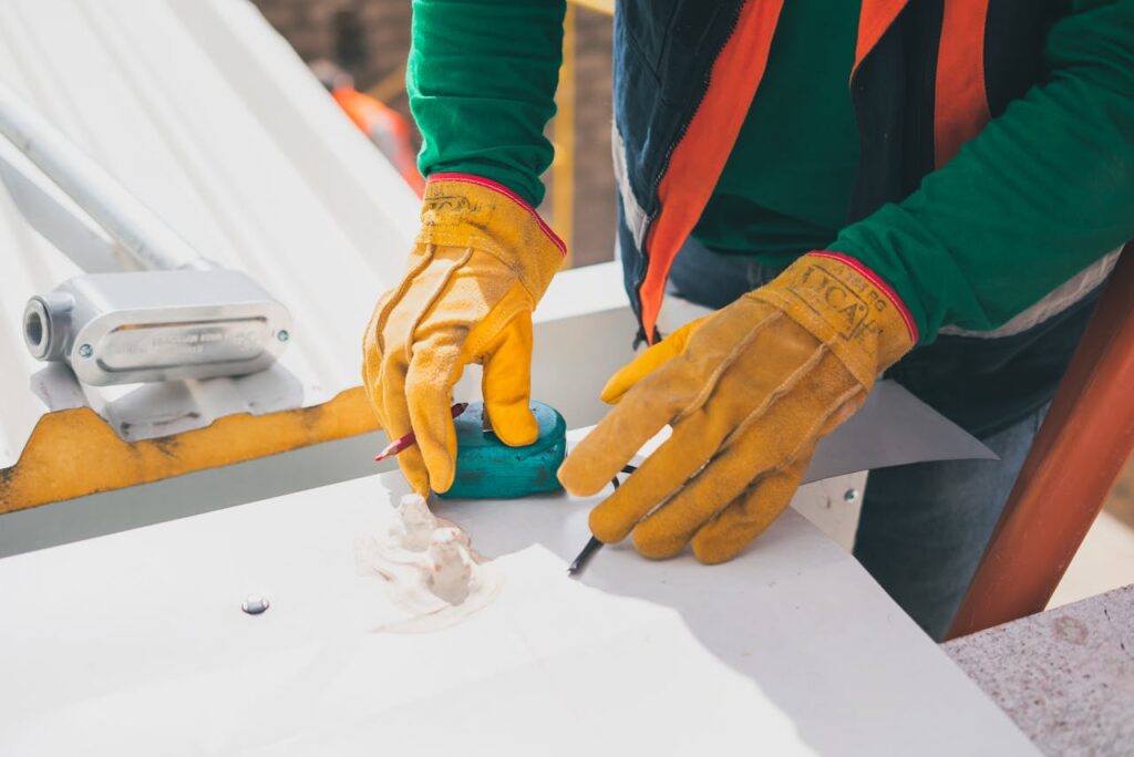 The Art of Drawing Readers In: Your attractive post title goes here Electrician measuring on rooftop, wearing protective gloves, during daylight.